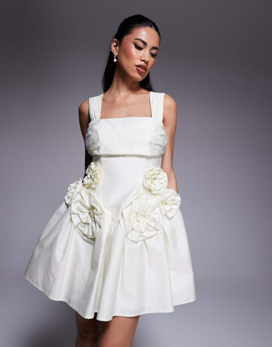 ASOS LUXE - Tailliertes Minikleid aus Baumwollsatin in Buttermilchgelb mit plissierter Brustpartie und Ansteckblumendetails ASOS LUXE - Tailliertes Minikleid aus Baumwollsatin in Buttermilchgelb mit plissierter Brustpartie und Ansteckblumendetails von ASOS LUXE