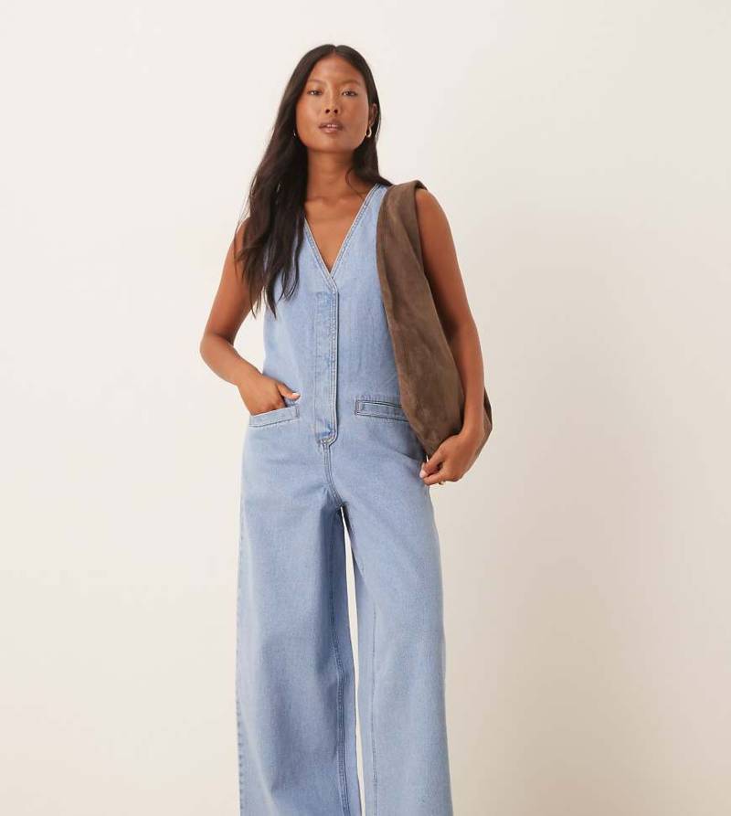 ASOS DESIGN Petite - Ärmelloser Denim-Jumpsuit in hellblauer Waschung mit Bindedetail auf der Rückseite von ASOS Petite