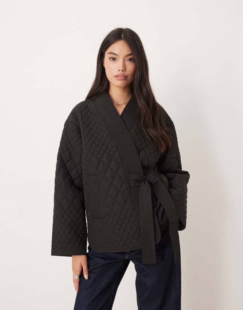 AWARE - Schlichte, gewickelte Steppjacke in Schwarz mit seitlichem Bindedetail von AWARE
