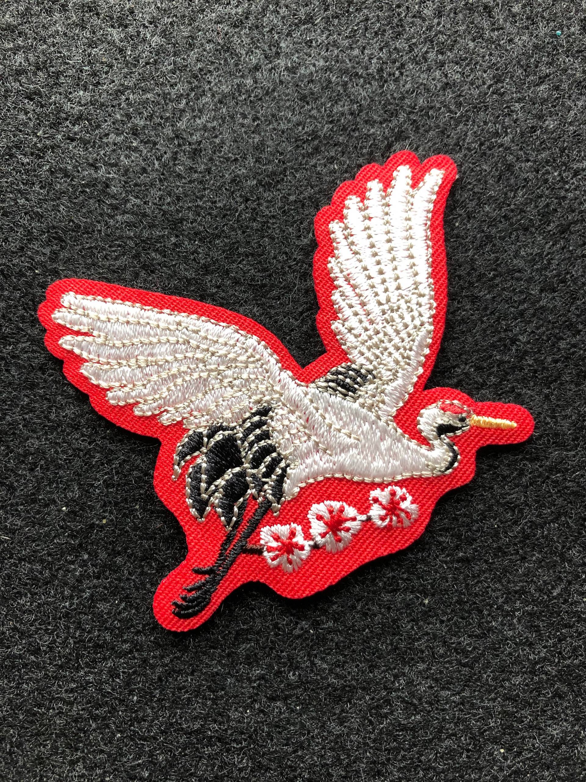Applikation - Reiher Bestickt in Weiß Und Schwarz Auf Rotem Hintergrund Bügelbild von AdelineMercantile