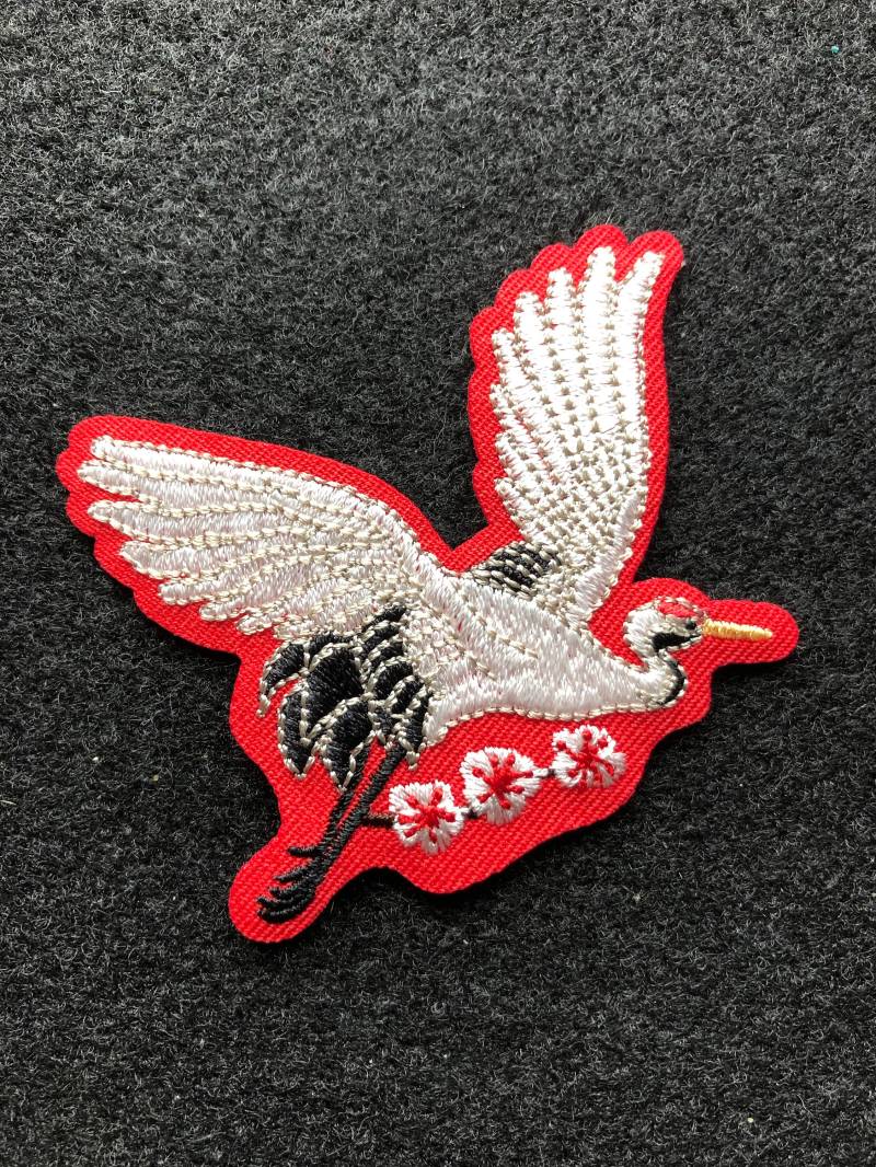 Applikation - Reiher Bestickt in Weiß Und Schwarz Auf Rotem Hintergrund Bügelbild von AdelineMercantile