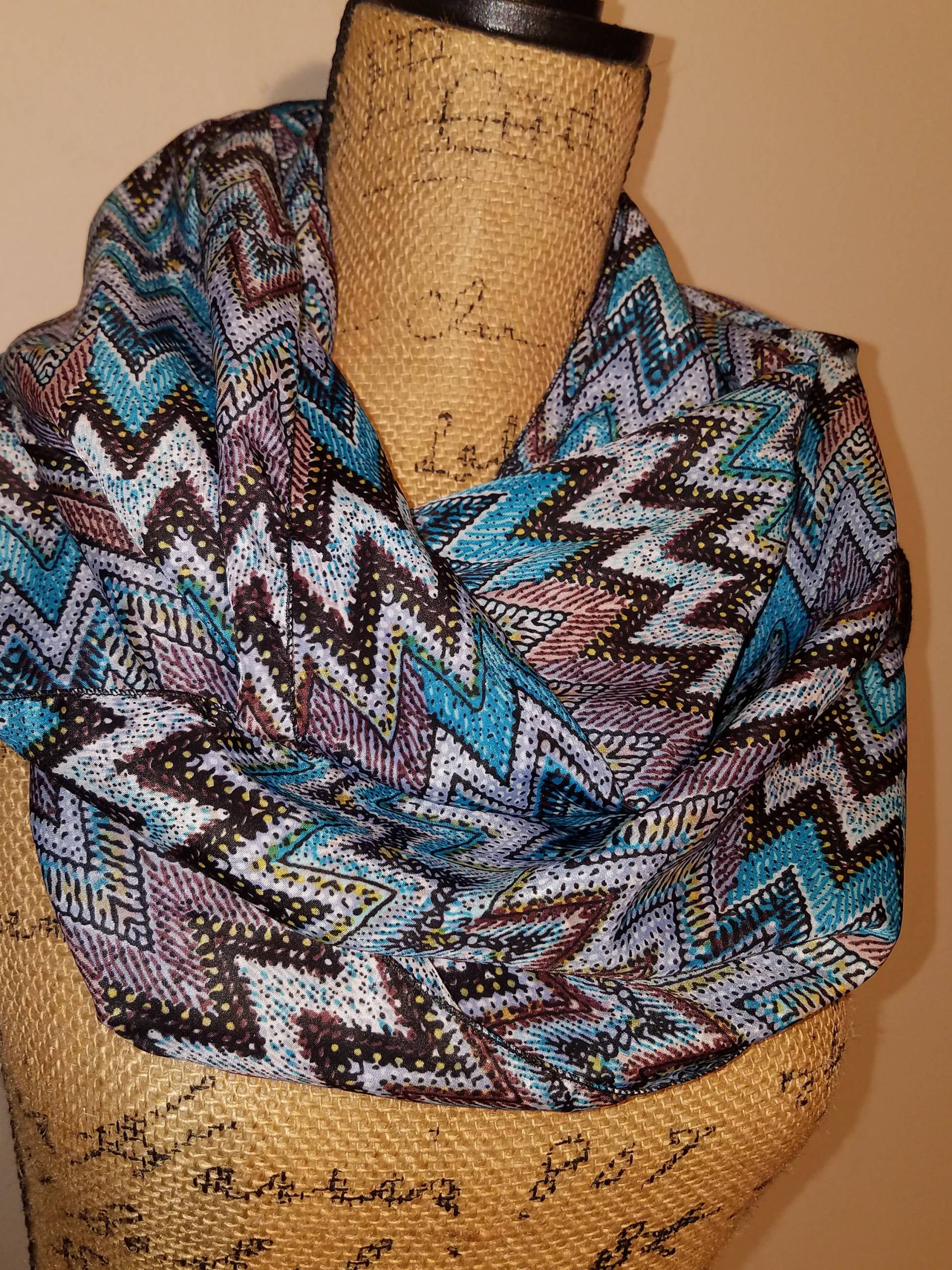 Seidiger Weicher Blauer Zick-Zack Schlauchschal Aus Polyester Mit Azteken-Muster Seidiger Weicher Blauer Zick-Zack Schlauchschal Aus Polyester Mit Azteken-Muster von AllScarvedUp