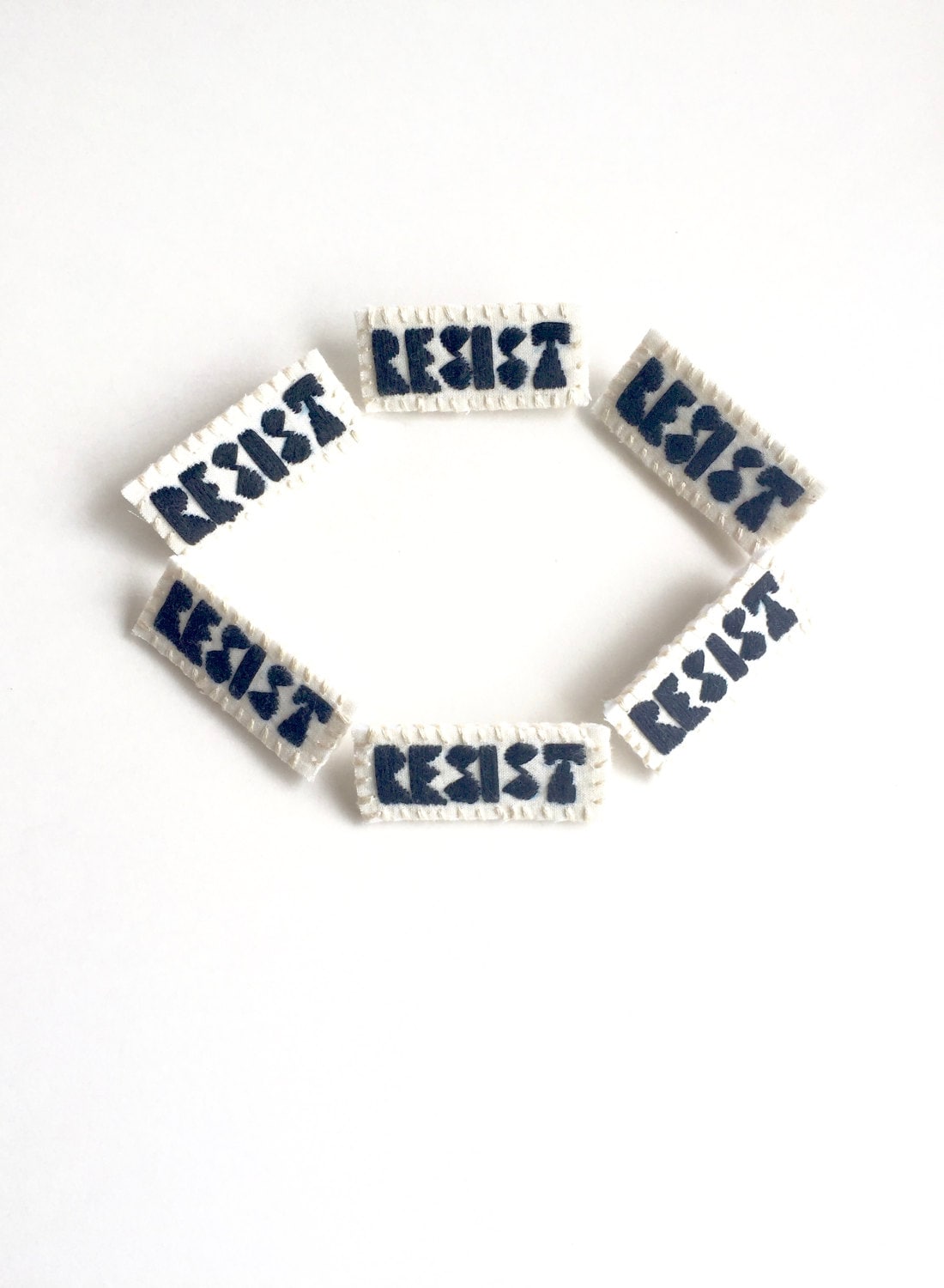 Handgestickte Brosche "Resist" Schwarzer Faden Auf Hellem Musselin Mit Stabiler Cremefarbener Filzrückseite Eine Astrid Endeavor Aktivistin." von AnAstridEndeavor
