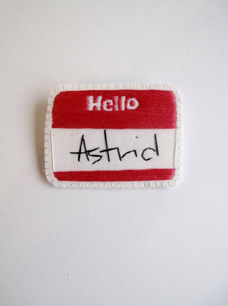 Personalisierte Hand Gestickt Namen Broschen Rot Hello Mit Ihrem Name in Schwarz Auf Creme Musselin Cremefarbenen Filzrücken Made To Order von AnAstridEndeavor