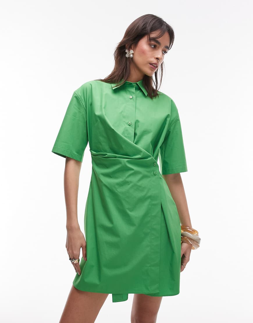 ARKET - Kurzes Hemdblusenkleid in Grün mit hohem Baumwollanteil und überkreuzter, geknöpfter Vorderseite ARKET - Kurzes Hemdblusenkleid in Grün mit hohem Baumwollanteil und überkreuzter, geknöpfter Vorderseite von Arket