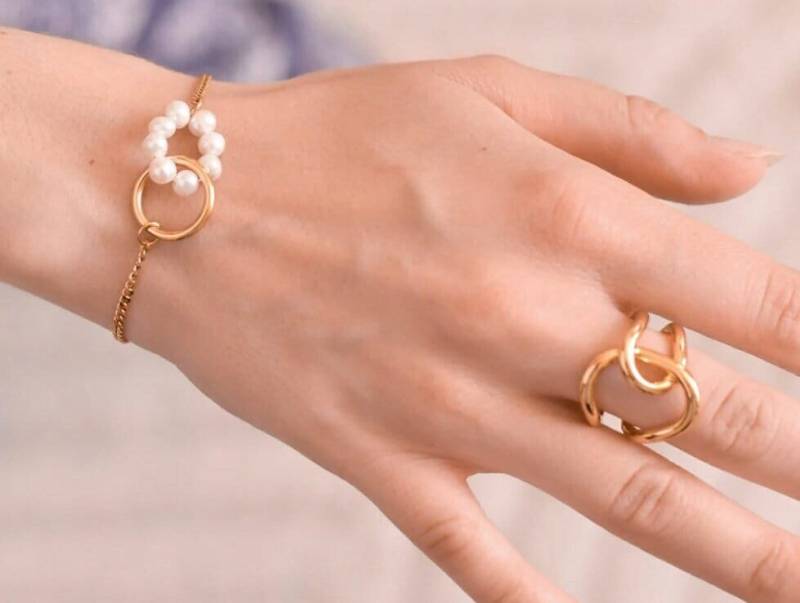 Feines Verstellbares Armband Mit Naturperlen Und Ineinander Verschlungenem Ring Aus Goldfarbenem Edelstahl von AtelierByMadeleine