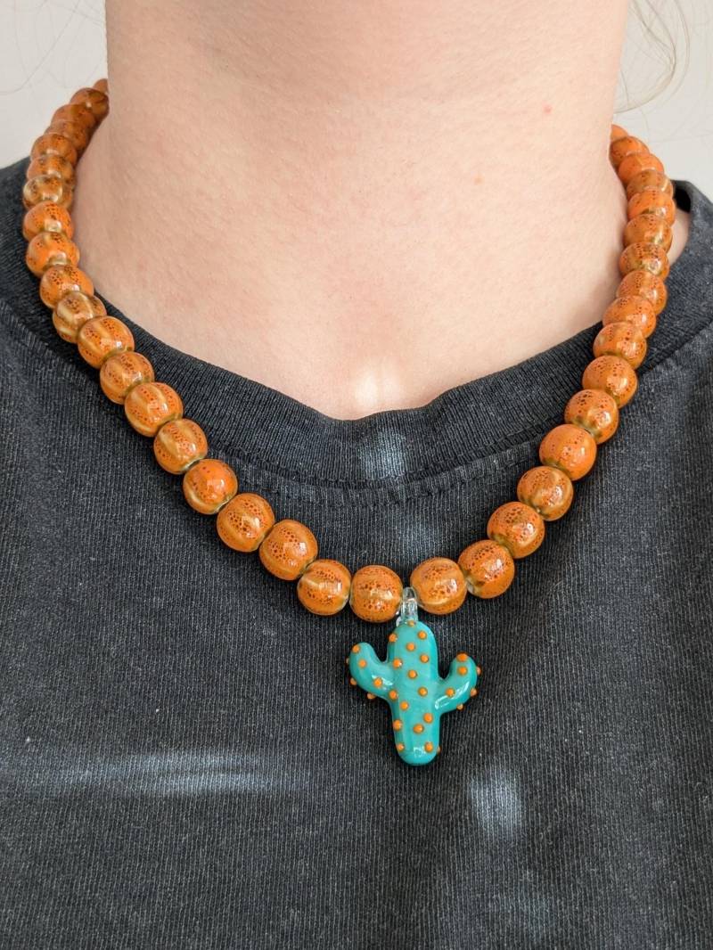 Solvina - Orange Ceramic Beaded Necklace With Green Glass Cactus Charm, Colorful Summer Jewelry, Bold Handmade Necklace, Gift Idea Solvina - Orange Ceramic Beaded Necklace With Green Glass Cactus Charm, Colorful Summer Jewelry, Bold Handmade Necklace, Gift Idea von AtelierLuanle