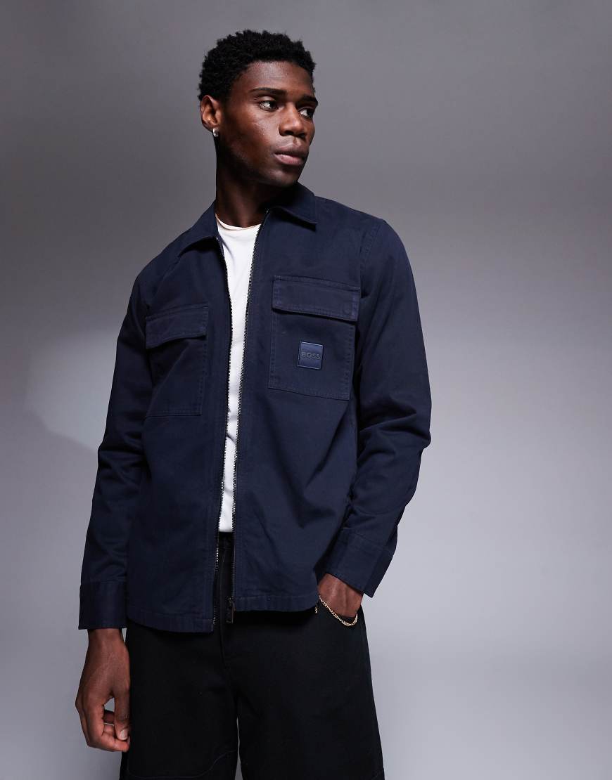 BOSS Orange - Lovel - Oversize-Hemdjacke in Marineblau mit Reißverschluss und Logo-Schild auf der Vorderseite BOSS Orange - Lovel - Oversize-Hemdjacke in Marineblau mit Reißverschluss und Logo-Schild auf der Vorderseite von BOSS Orange