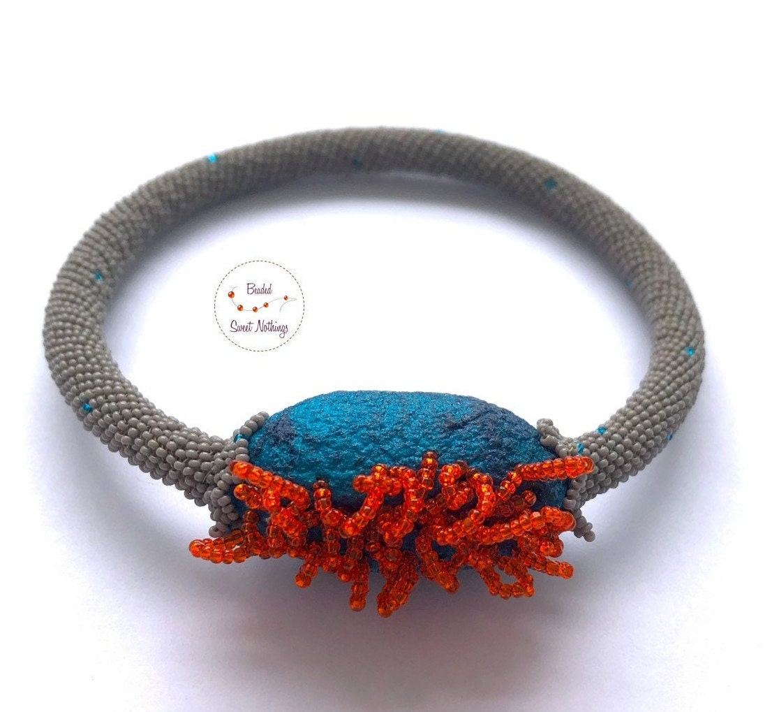 Seidenkokon-Armreif Aus Grauen Mini-Glasperlen. Handgefädelt Mit Einem Petrolfarbenen Seidenkokon Und Orangefarbenen Vintage Charlottes von BeadedSweetNothings