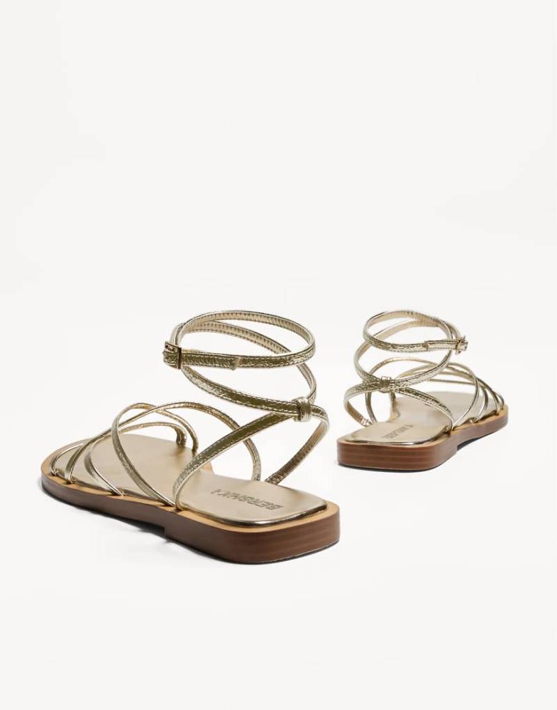 Bershka - Flache Sandalen mehreren Riemen in Gold-Goldfarben von Bershka