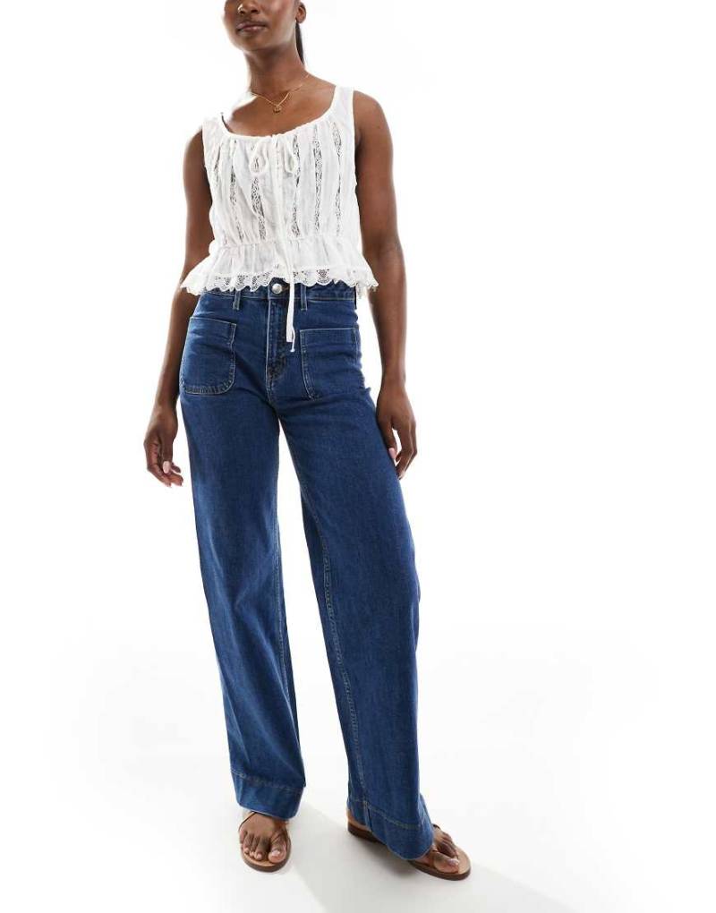 Bershka - Jeans in mittelblauer Waschung mit hohem Bund und Tasche von Bershka