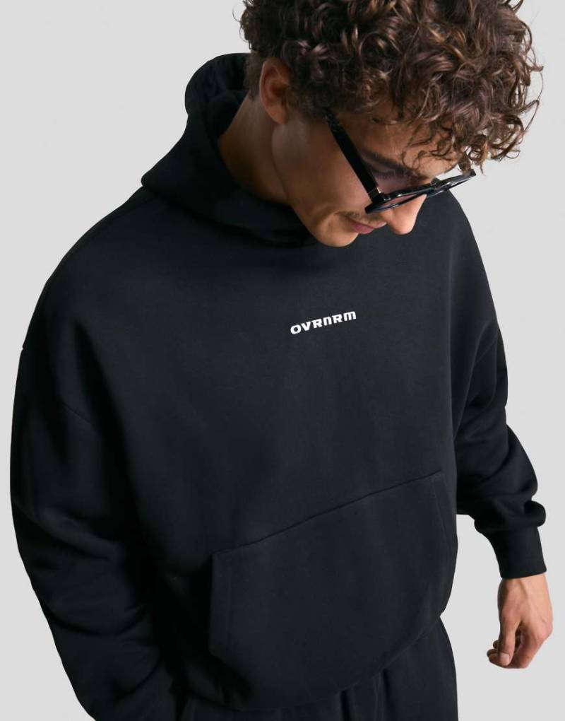 Bershka - Kastiger Kapuzenpullover in Schwarz mit Print von Bershka