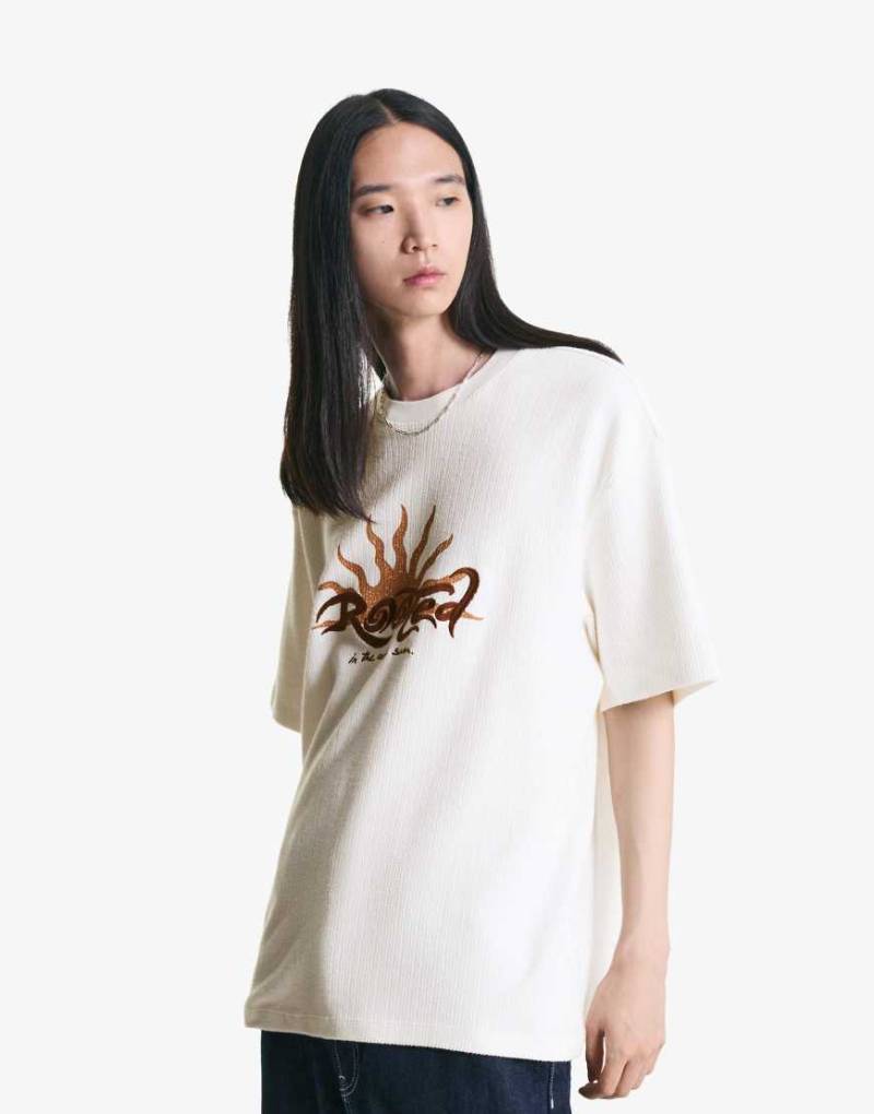 Bershka - Kurzärmliges, strukturiertes T-Shirt in Weiß mit Stickerei von Bershka