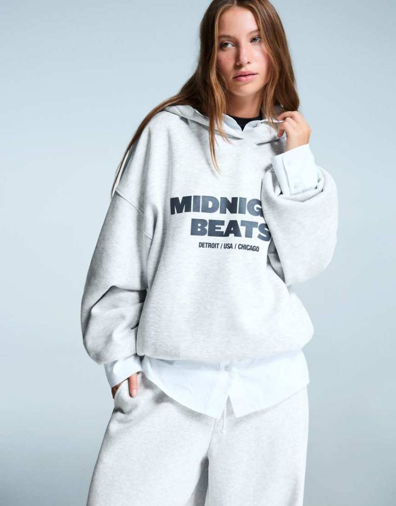 Bershka - Oversize-Kapuzenpullover in Hellgrau mit Aufdruck Bershka - Oversize-Kapuzenpullover in Hellgrau mit Aufdruck von Bershka