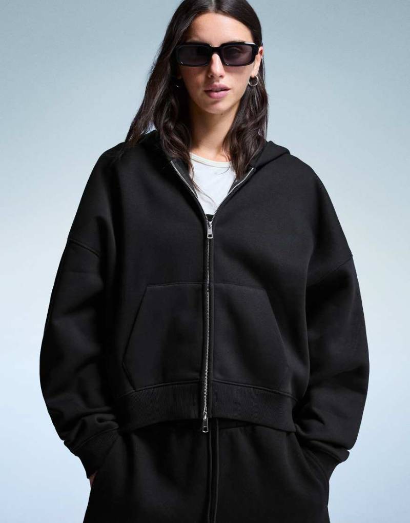 Bershka - Oversize-Kapuzenpullover in Schwarz mit Reißverschluss Bershka - Oversize-Kapuzenpullover in Schwarz mit Reißverschluss von Bershka