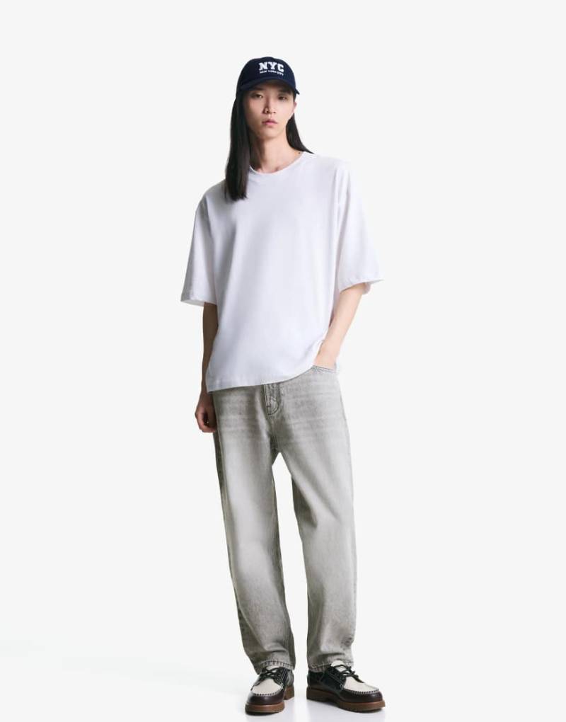 Bershka - Schmal zulaufende, locker geschnittene Jeans in Hellgrau von Bershka