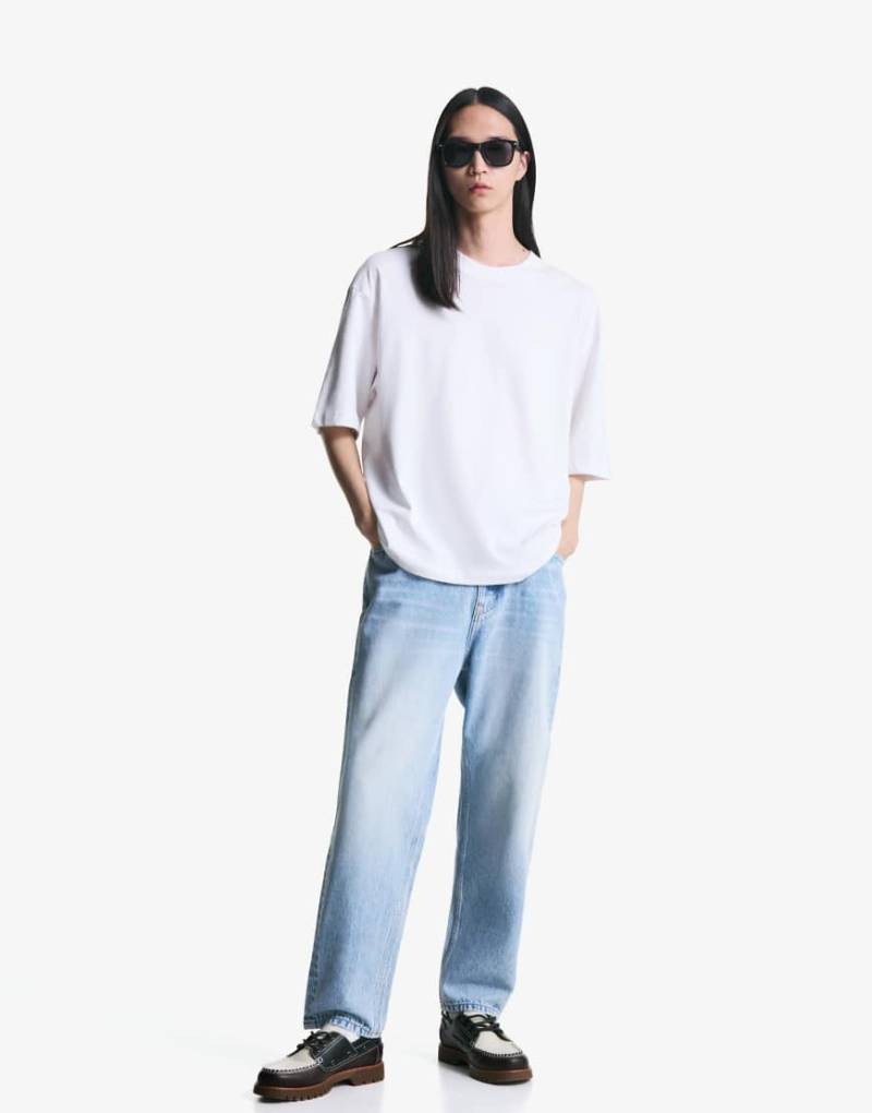 Bershka - Schmal zulaufende, locker geschnittene Jeans in Mittelblau von Bershka