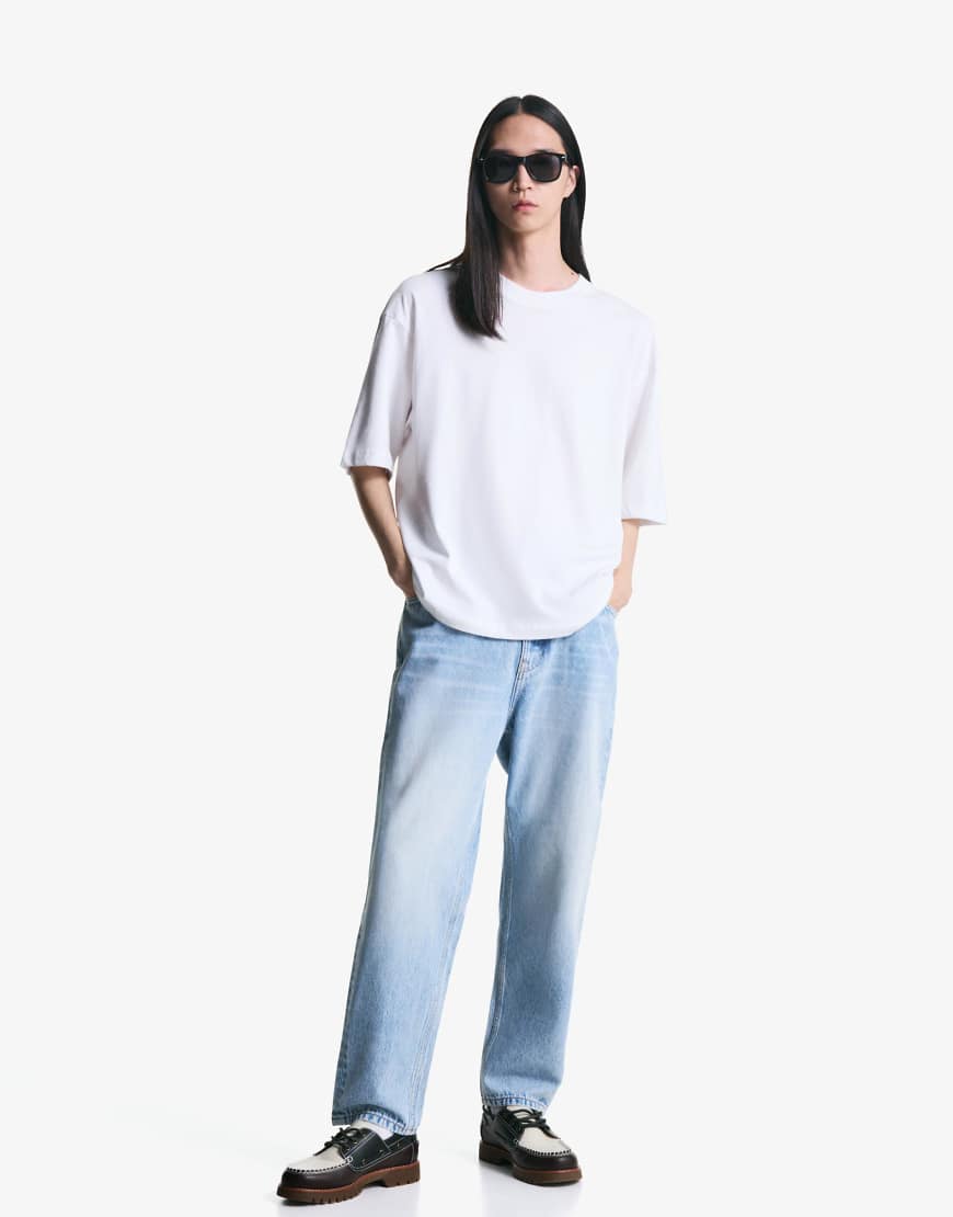 Bershka - Schmal zulaufende, locker geschnittene Jeans in Mittelblau von Bershka