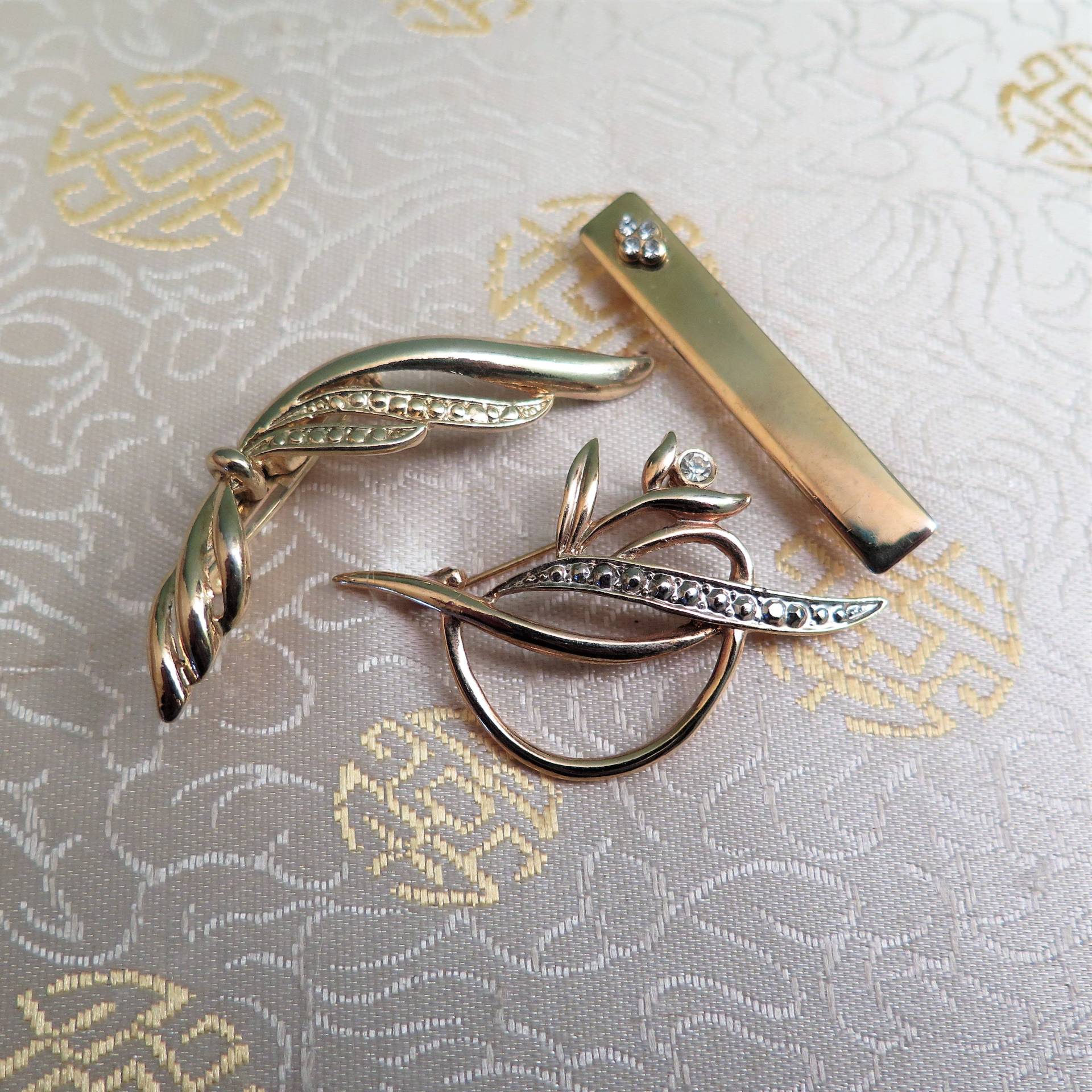 Set Aus Drei Goldfarbenen Broschen, Zwei Davon Mit Strass, Um 1980 Set Aus Drei Goldfarbenen Broschen, Zwei Davon Mit Strass, Um 1980 von BlitheSpiritVintage