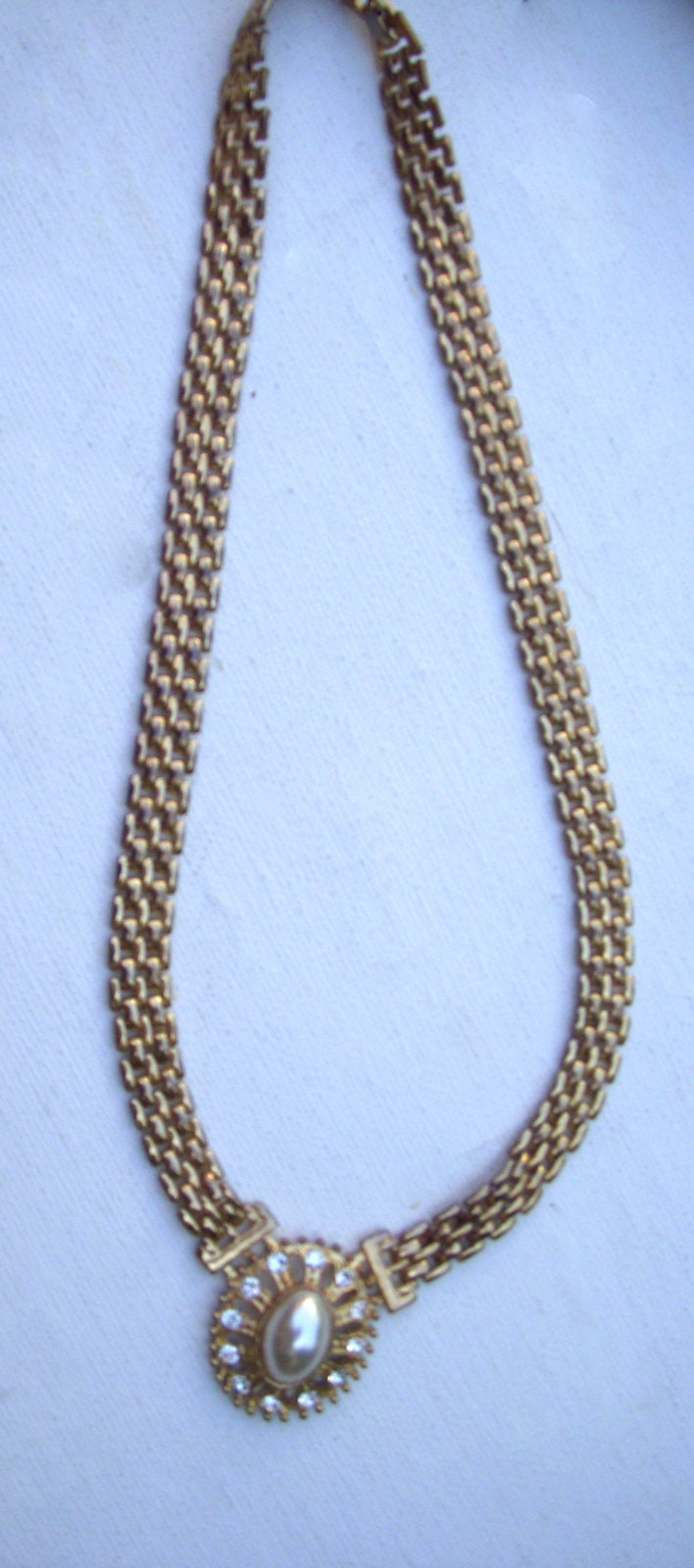 Vintage Kräftige Goldfarbene Metallhalskette Mit Flacher Kette Und Ovalem Perlmuttfarbenem Anhänger Strass Besetztem Rahmen, Circa 80Er Jahre Vintage Kräftige Goldfarbene Metallhalskette Mit Flacher Kette Und Ovalem Perlmuttfarbenem Anhänger Strass Besetztem Rahmen, Circa 80Er Jahre von BoxV