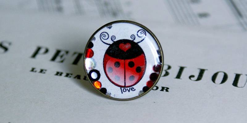 Harz Und Bronze Metallring Mit Einem Liebe Marienkäfer Illustration von COMME1ange