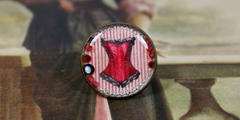 Ring Aus Harz Und Bronze Metall Mit Einem Roten Korsett Illustration von COMME1ange