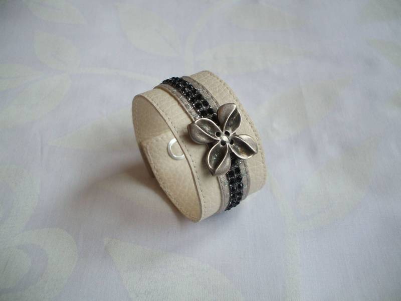 Manschettenarmband Aus Ecrufarbenem Kunstleder, Strassbändern Und Stilisierter Blume Manschettenarmband Aus Ecrufarbenem Kunstleder, Strassbändern Und Stilisierter Blume von CREATIONSMURIELHULOT