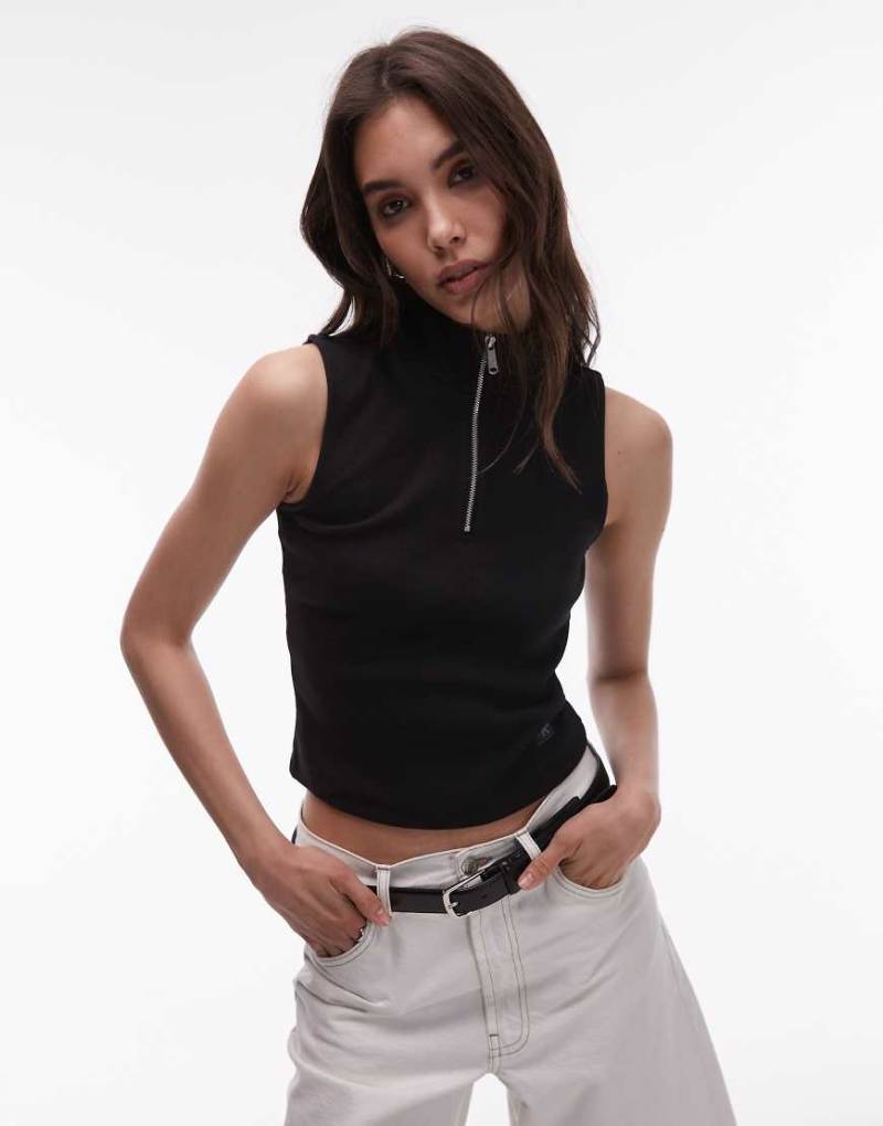 Calvin Klein Jeans - Ärmelloses Cropped-Oberteil in Schwarz mit gewebtem Aufnäher und kurzem Reißverschluss von Calvin Klein Jeans