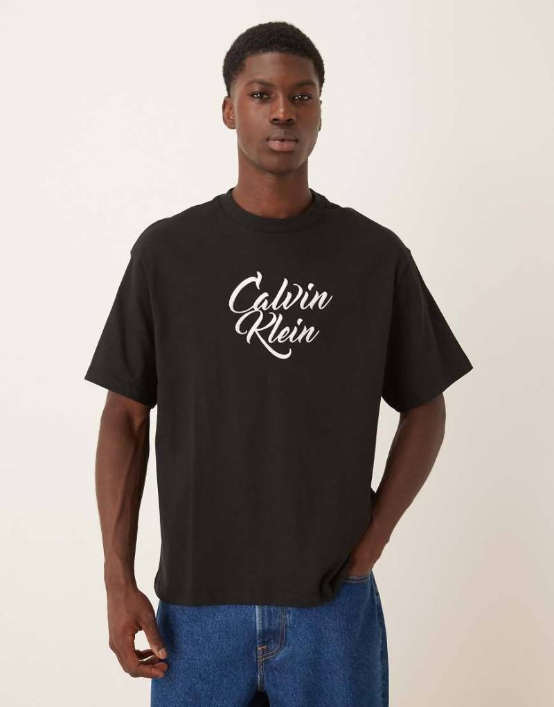 Calvin Klein Jeans - T-Shirt in Schwarz mit großem Grafik-Schriftzug Calvin Klein Jeans - T-Shirt in Schwarz mit großem Grafik-Schriftzug von Calvin Klein Jeans