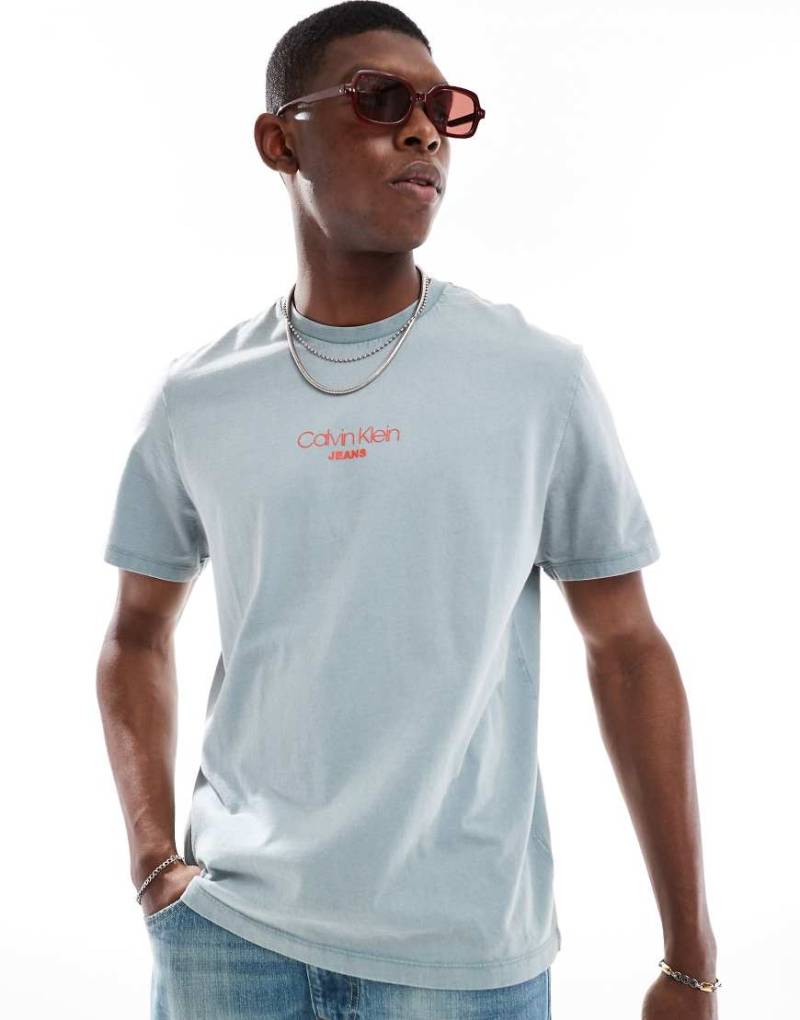 Calvin Klein - T-Shirt in verwaschenem Blau mit kleinem mittigem Logo-Grün Calvin Klein - T-Shirt in verwaschenem Blau mit kleinem mittigem Logo-Grün von Calvin Klein Jeans