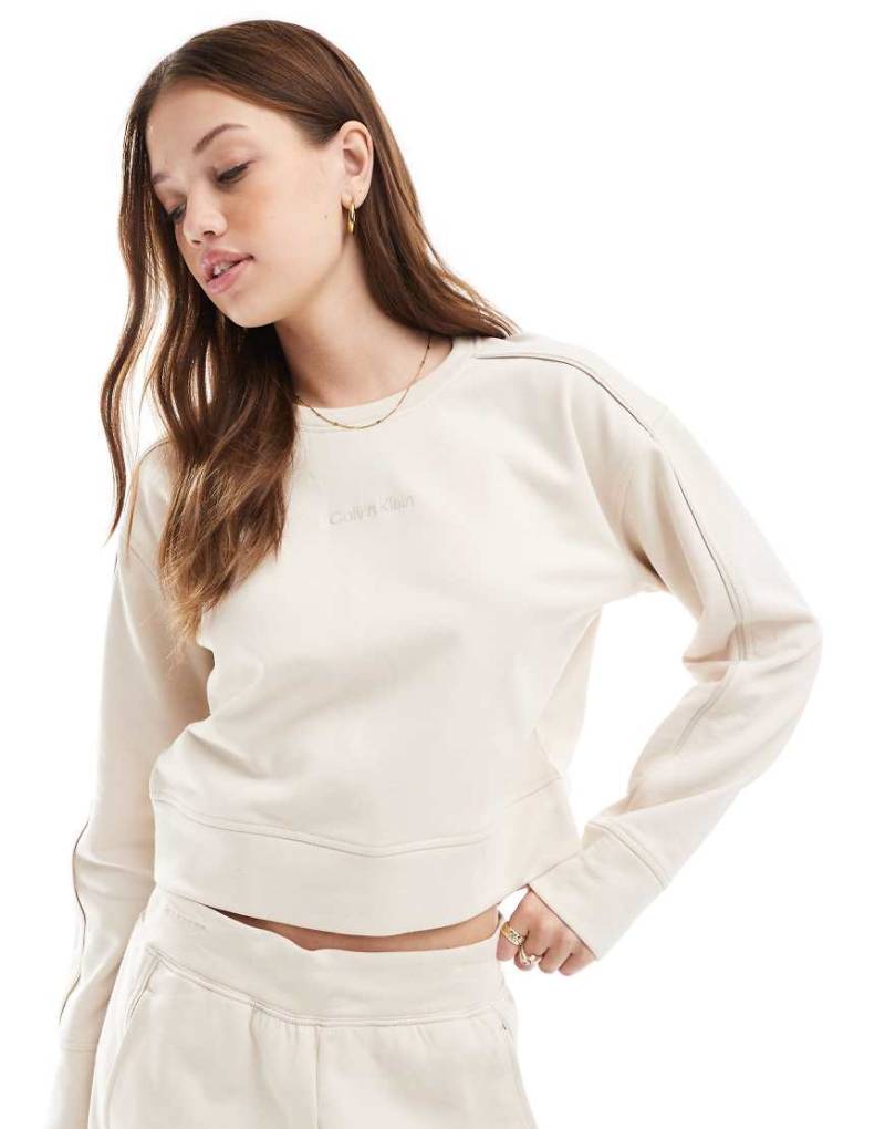 Calvin Klein - Lounge-Sweatshirt in Creme mit Rundhalsausschnitt und farblich abgestimmtem Logo-Weiß Calvin Klein - Lounge-Sweatshirt in Creme mit Rundhalsausschnitt und farblich abgestimmtem Logo-Weiß von Calvin Klein