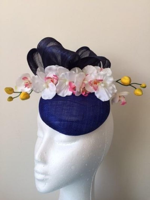 Atemberaubender Blauer Fascinator Mit Seidenschleifen Und Weißen Orchideen Atemberaubender Blauer Fascinator Mit Seidenschleifen Und Weißen Orchideen von CanteringDesigns