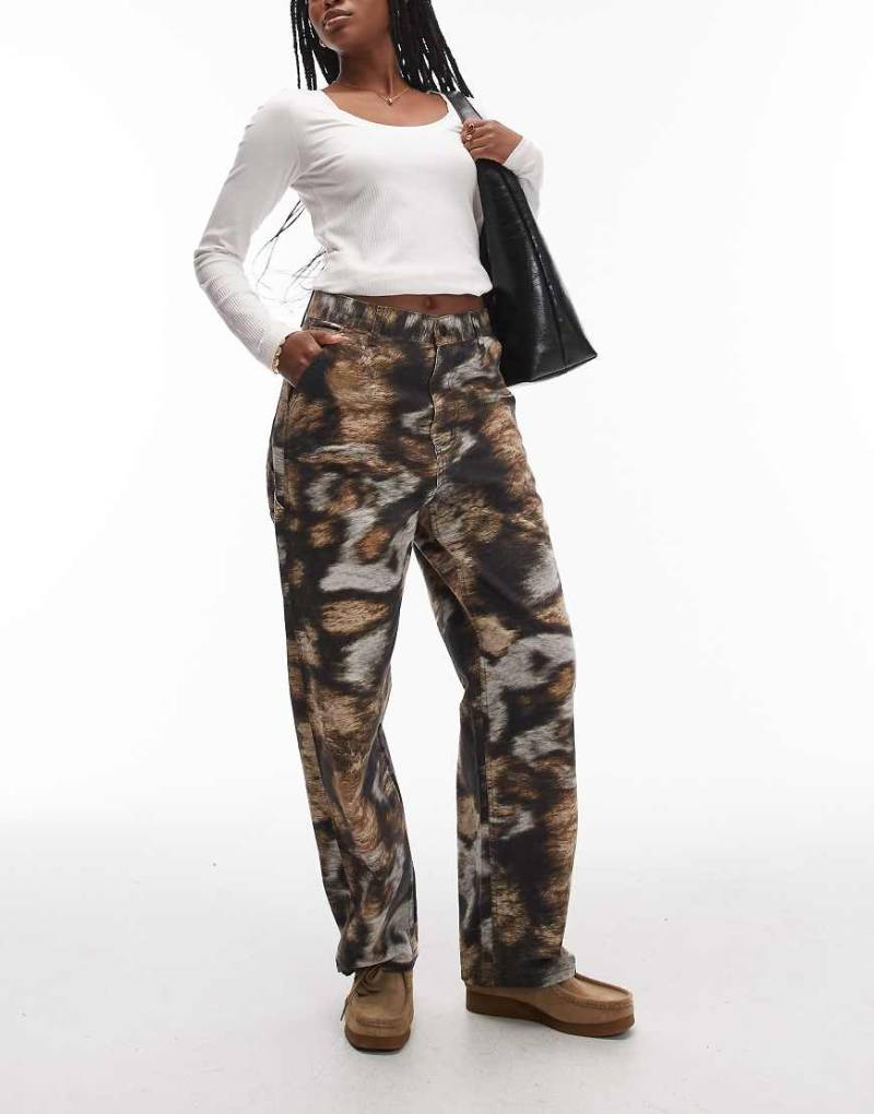 Carhartt WIP - Brandon - Lockere Hose mit Detail an einem Knie und Wilde-Hunde-Tarnmuster-Bunt Carhartt WIP - Brandon - Lockere Hose mit Detail an einem Knie und Wilde-Hunde-Tarnmuster-Bunt von Carhartt WIP