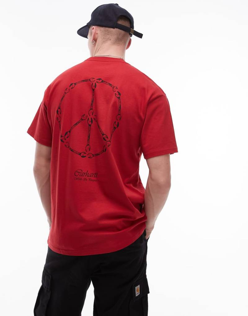 Carhartt WIP - T-Shirt in Rot mit Friedenszeichen- und Work-Grafik von Carhartt WIP
