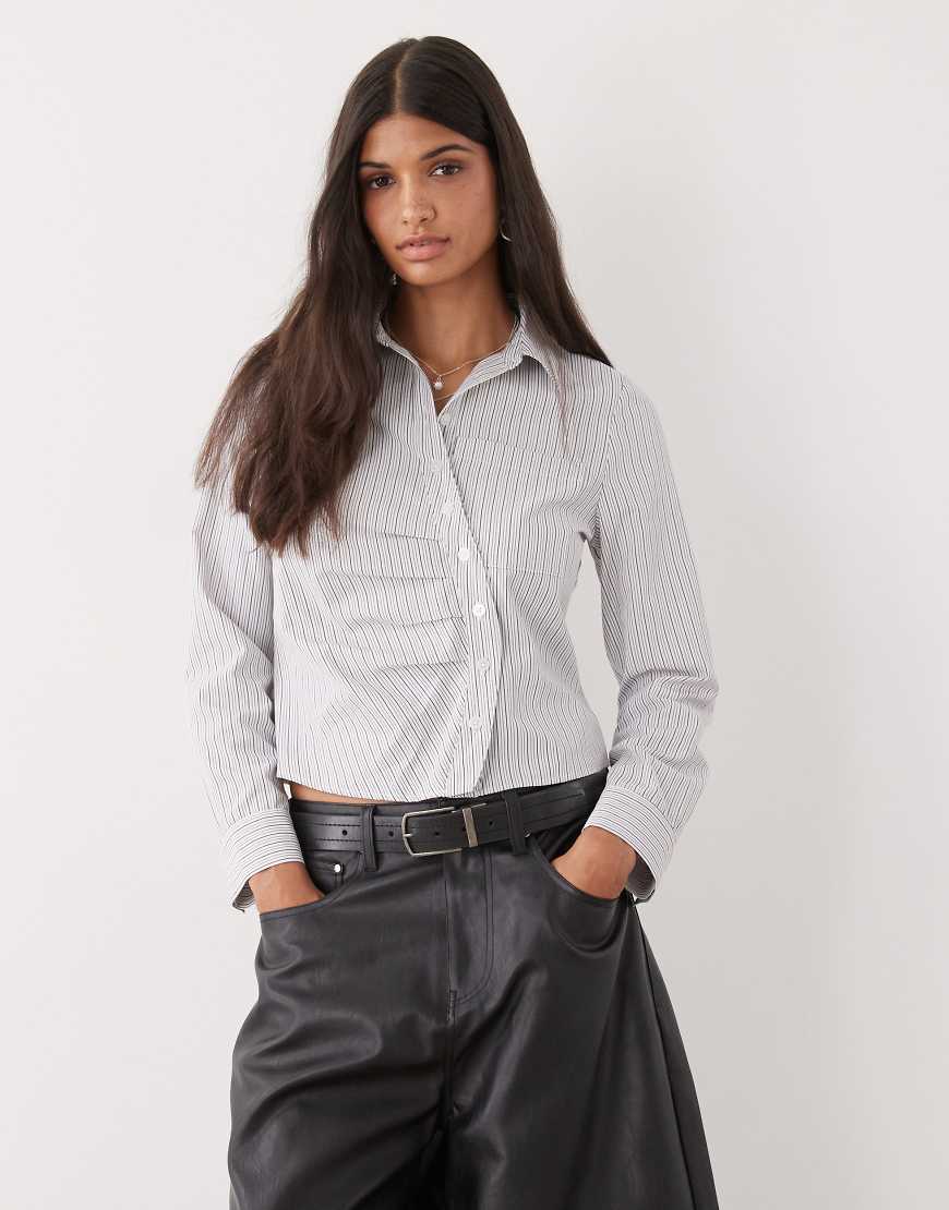 COLLUSION - Figurbetonte Hemdbluse in Blau gestreift mit verdrehter Knopfleiste COLLUSION - Figurbetonte Hemdbluse in Blau gestreift mit verdrehter Knopfleiste von Collusion