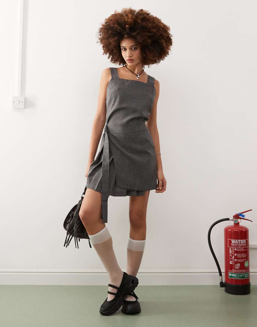 COLLUSION - Mini-Latzkleid in Grau im Schottenrock-Teil und Schnallendetail von Collusion