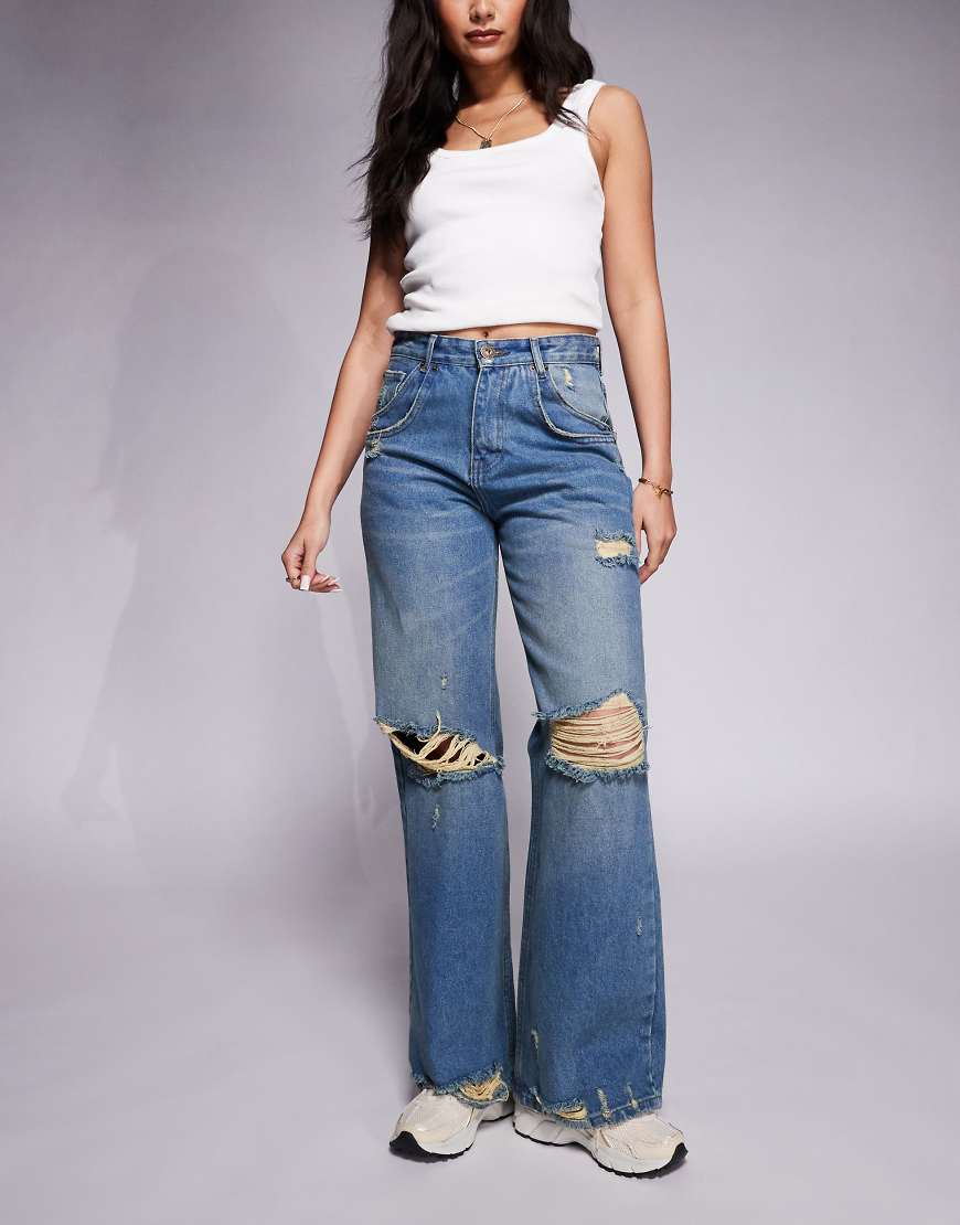 Courtside - Weit geschnittene Jeans in verwaschenem Blau mit extremen Abnutzungsdetails Courtside - Weit geschnittene Jeans in verwaschenem Blau mit extremen Abnutzungsdetails von Courtside