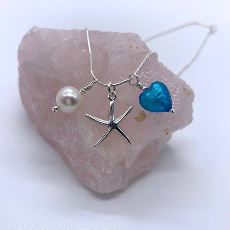 Diana Ingram Drei Bettelkette Aus Sterling Silber Mit Türkisem | Blauem Muranoglas Herz, Seestern, Weißer Perle Und Schlangenkette Diana Ingram Drei Bettelkette Aus Sterling Silber Mit Türkisem | Blauem Muranoglas Herz, Seestern, Weißer Perle Und Schlangenkette von DianaIngramJewellery