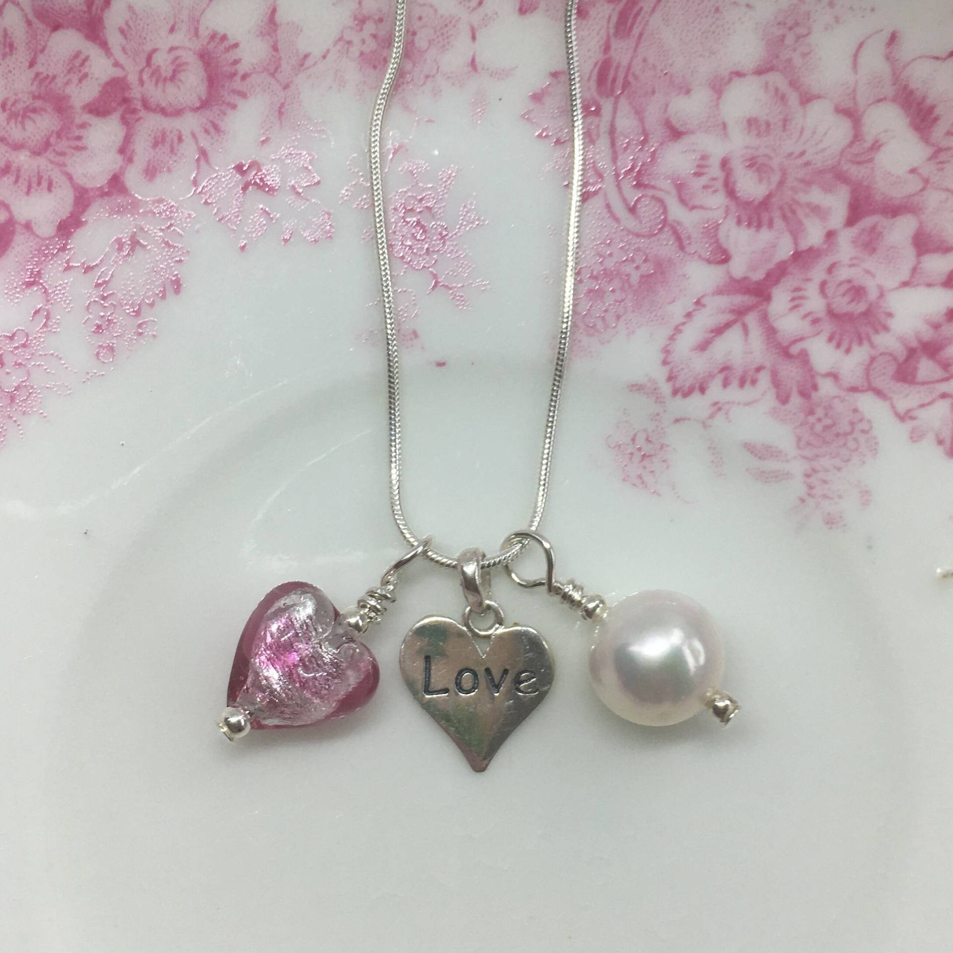 Diana Ingram Drei Charm Halskette Aus Sterling Silber Mit Candy Streifen Rosa Muranoglas Herz, "Liebe' Weiße Perle Und Schlangenkette Diana Ingram Drei Charm Halskette Aus Sterling Silber Mit Candy Streifen Rosa Muranoglas Herz, "Liebe' Weiße Perle Und Schlangenkette von DianaIngramJewellery