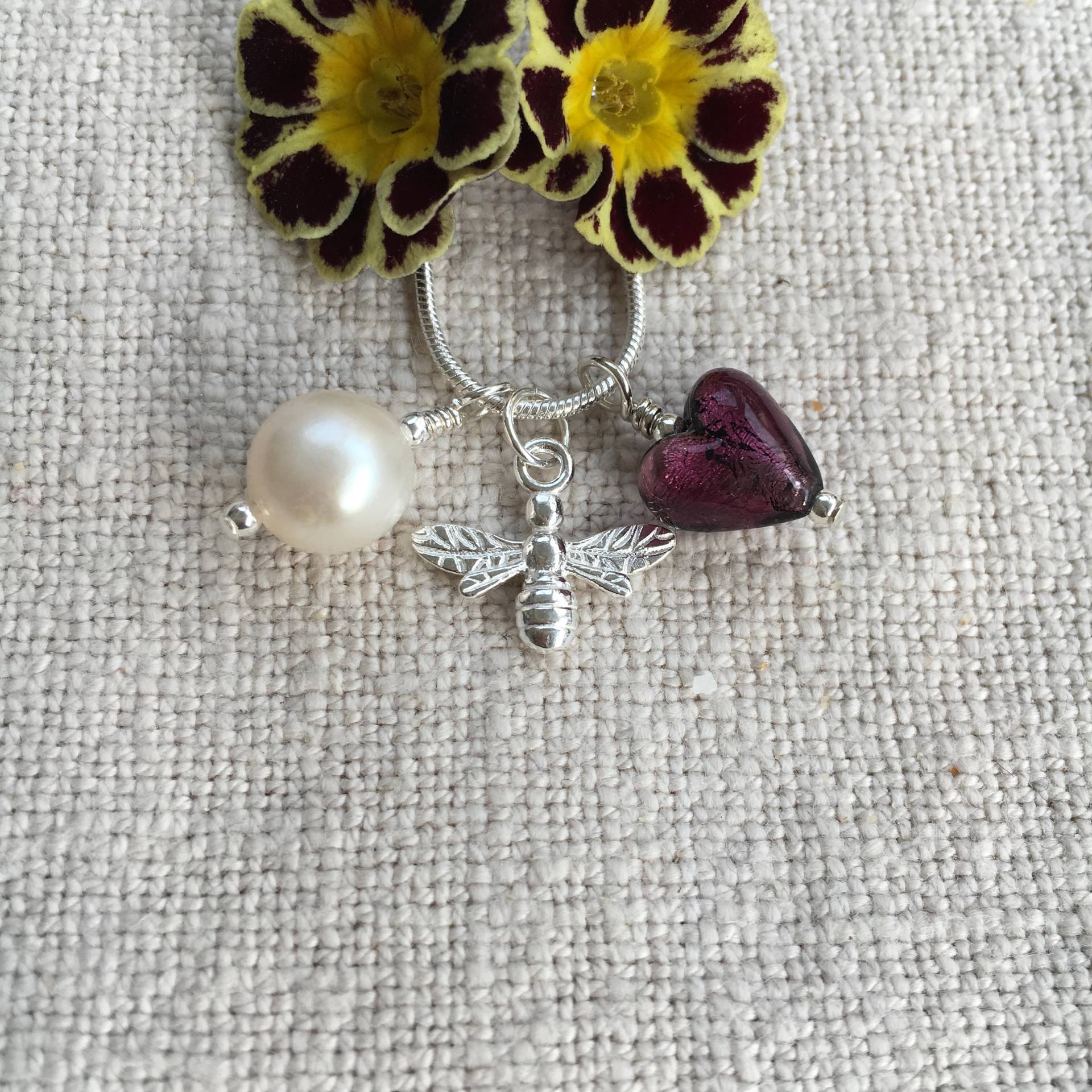 Diana Ingram Drei Charm Halskette Aus Sterling Silber Mit Dunklem Amethyst | Lila Murano Glas Herz, Honigbiene, Weißer Perle Und Schlangenkette Diana Ingram Drei Charm Halskette Aus Sterling Silber Mit Dunklem Amethyst | Lila Murano Glas Herz, Honigbiene, Weißer Perle Und Schlangenkette von DianaIngramJewellery