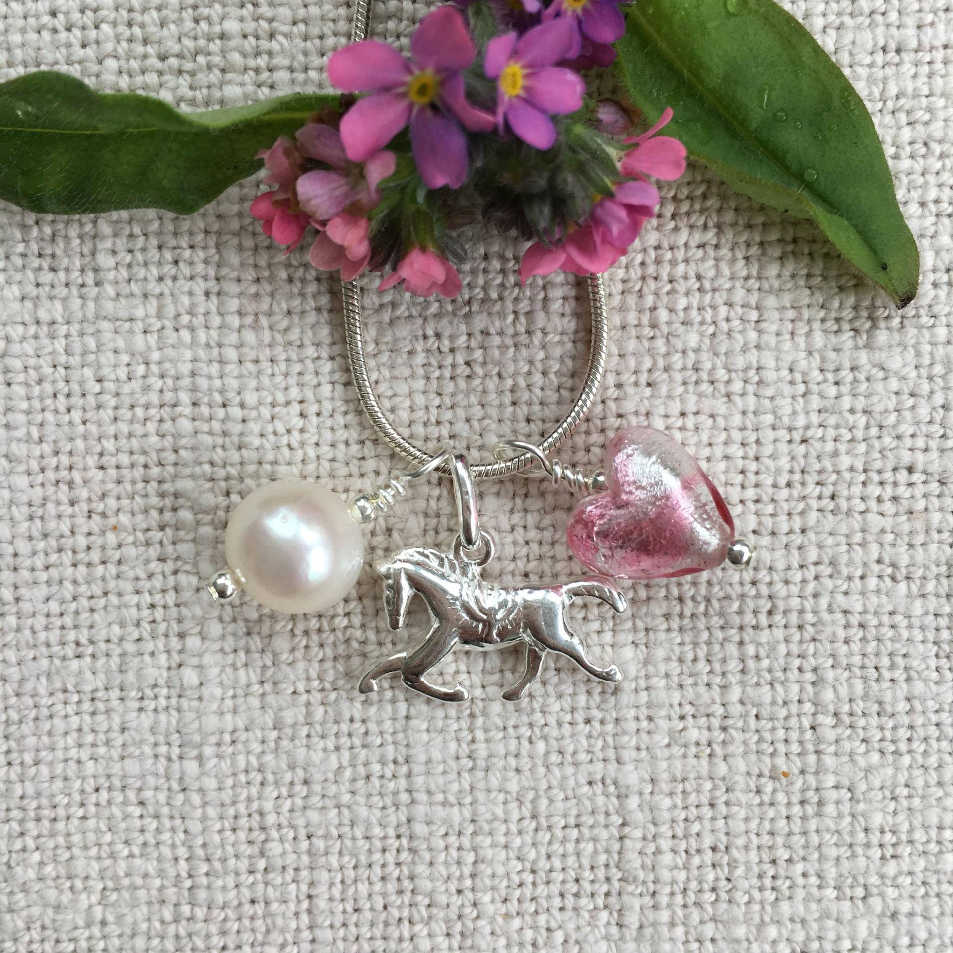 Diana Ingram Drei Charm Halskette in Sterling Silber Mit Candy Streifen Rosa Muranoglas Herz, Pferd, Weiße Perle Und Schlangenkette Diana Ingram Drei Charm Halskette in Sterling Silber Mit Candy Streifen Rosa Muranoglas Herz, Pferd, Weiße Perle Und Schlangenkette von DianaIngramJewellery