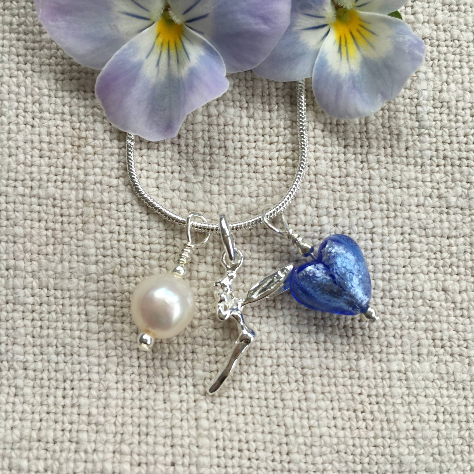 Diana Ingram Drei Charm Halskette in Sterling Silber Mit Kornblumen Blauem Murano Glas Herz, Waldelfee, Weißer Perle Und Schlangenkette Diana Ingram Drei Charm Halskette in Sterling Silber Mit Kornblumen Blauem Murano Glas Herz, Waldelfee, Weißer Perle Und Schlangenkette von DianaIngramJewellery