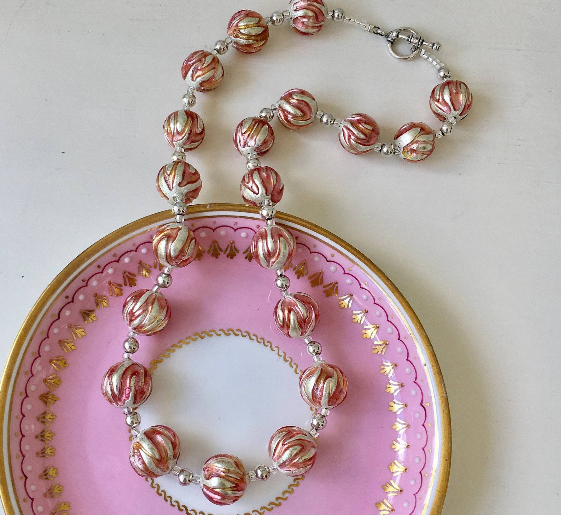 Diana Ingram Halskette Mit Rosa Applikation Über Weißgoldenen Kugelperlen Aus Muranoglas Auf Sterlingsilberperlen Und Verschluss Diana Ingram Halskette Mit Rosa Applikation Über Weißgoldenen Kugelperlen Aus Muranoglas Auf Sterlingsilberperlen Und Verschluss von DianaIngramJewellery