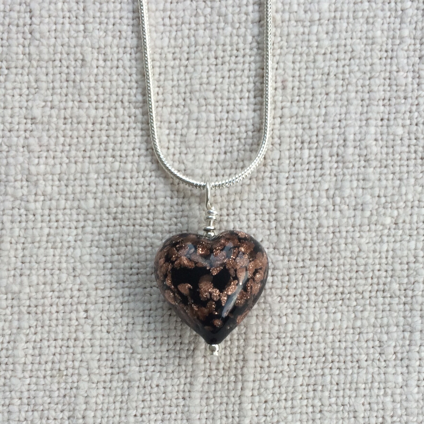 Diana Ingram Halskette Mit Schwarzem Pastell Anhänger Und Kleinem Herz Aus Aventurin-Muranoglas An Einer Schlangenkette Sterling Silber Diana Ingram Halskette Mit Schwarzem Pastell Anhänger Und Kleinem Herz Aus Aventurin-Muranoglas An Einer Schlangenkette Sterling Silber von DianaIngramJewellery