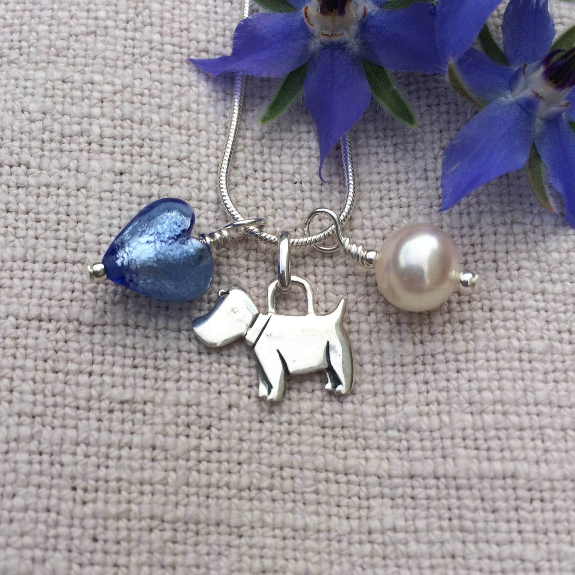 Diana Ingram Three Charm Halskette Aus Sterling Silber Mit Kornblumen Blauem Muranoglas Herz, Hund, Weißer Perle Und Schlangenkette Diana Ingram Three Charm Halskette Aus Sterling Silber Mit Kornblumen Blauem Muranoglas Herz, Hund, Weißer Perle Und Schlangenkette von DianaIngramJewellery