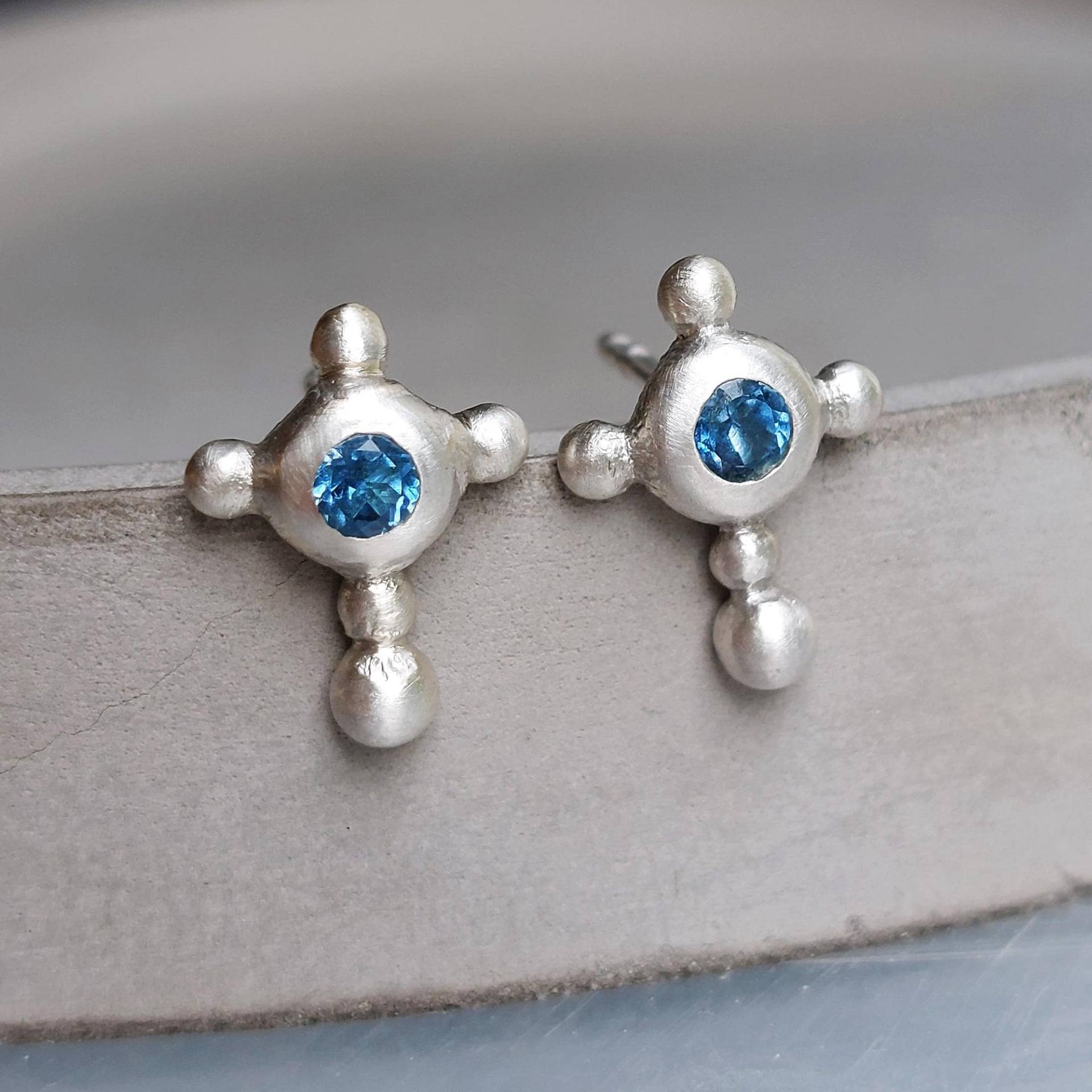 Petrolblaue Swiss-Topas Kreuzohrstecker in 925 Silber Handgemachte Kugelige Unikat-Silberkreuze Mit Funkelndem Blauen Edelstein - Dsiho von Dsiho