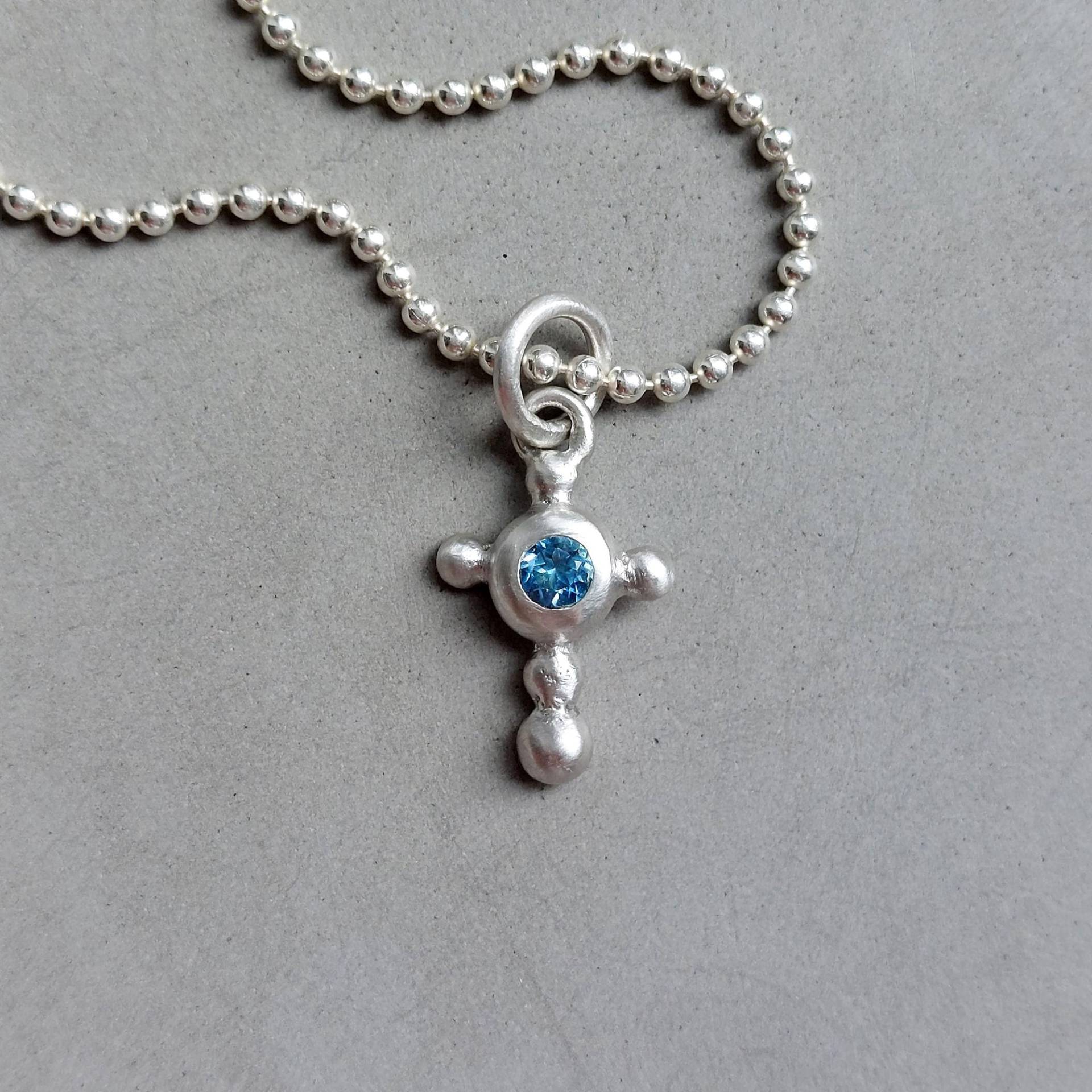 Petrolblauer Swiss-Topas Kreuzanhänger in 925 Silber Handgemachtes Kugeliges Unikat-Silberkreuz Mit Funkelndem Blauen Edelstein - Dsiho von Dsiho