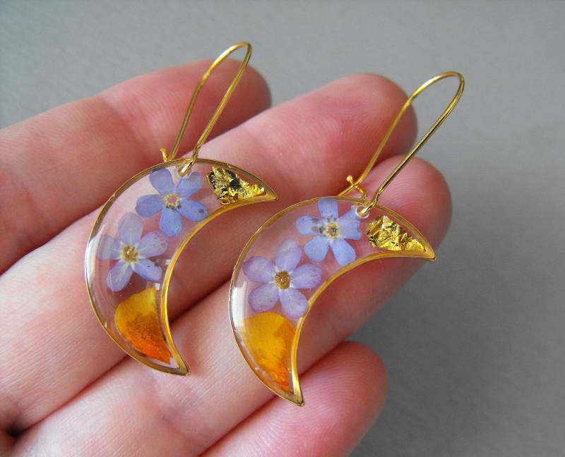 Halbmond-Ohrringe Mit Vergissmeinnicht-Blüten, Goldflocken Und Orangefarbenen Blütenblättern. Edelstahl Halbmond-Ohrringe Mit Vergissmeinnicht-Blüten, Goldflocken Und Orangefarbenen Blütenblättern. Edelstahl von Eratherba