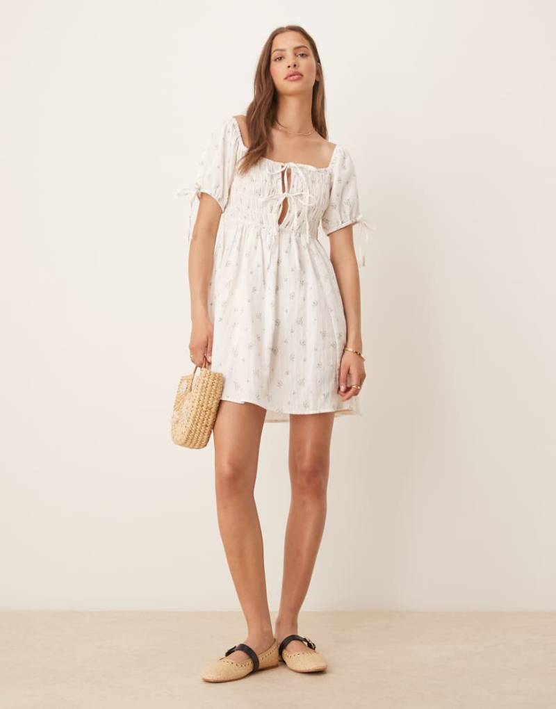 Esmee - Exclusive - Mini-Strandkleid in Weiß mit gebundener Vorderseite, Puffärmeln und Blümchenmuster von Esmée