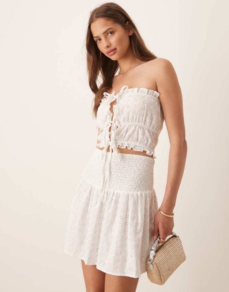 Esmée - Exclusive - Trägerloses Cropped-Oberteil in Weiß mit Lochstickerei, gebundener Vorderseite und Rüschensaum von Esmée